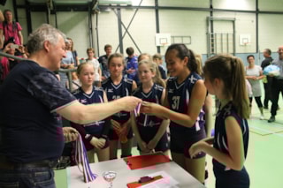 Wedstrijdleider Gerard Witte deelt de medailles uit